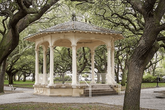 Historic white gazebo bandstand surrounded by large live oak trees at White Point Garden in Charleston, South
  Carolina.